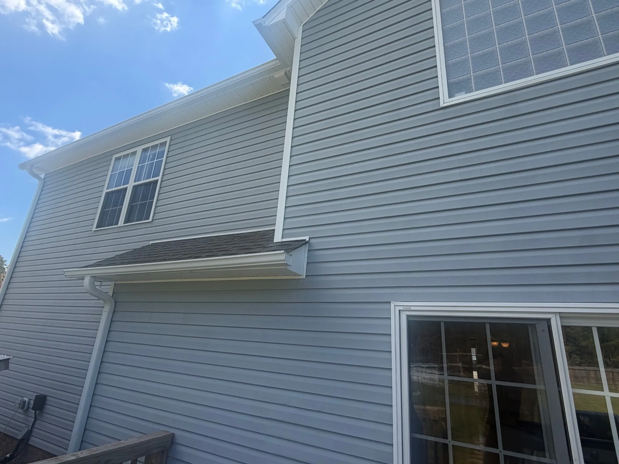 Two-story house siding fully restored after soft wash cleaning in Jacksonville NC