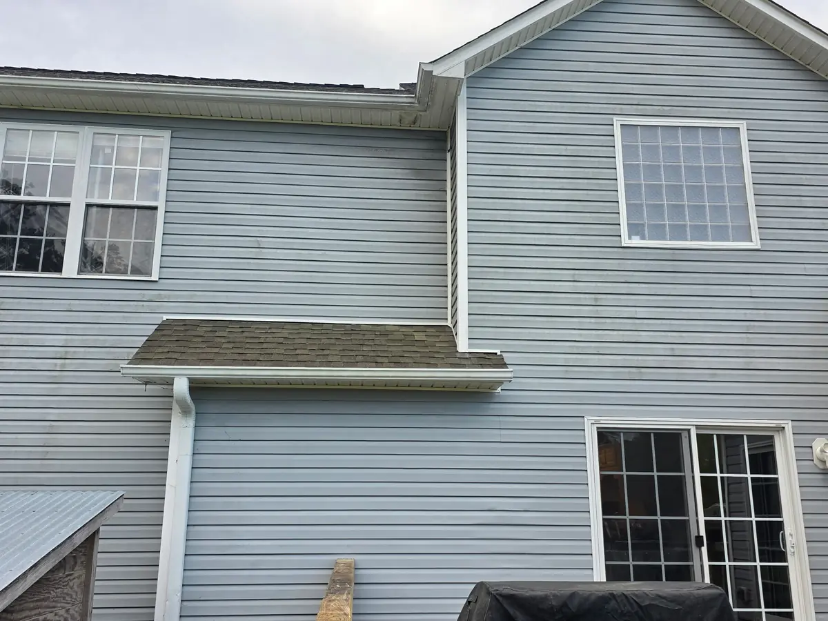 Before: blue vinyl siding home with algae and biological buildup before soft wash