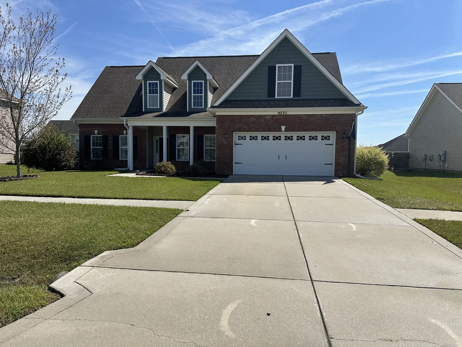 After: brick and vinyl two-story house with clean driveway fully restored in Jacksonville NC