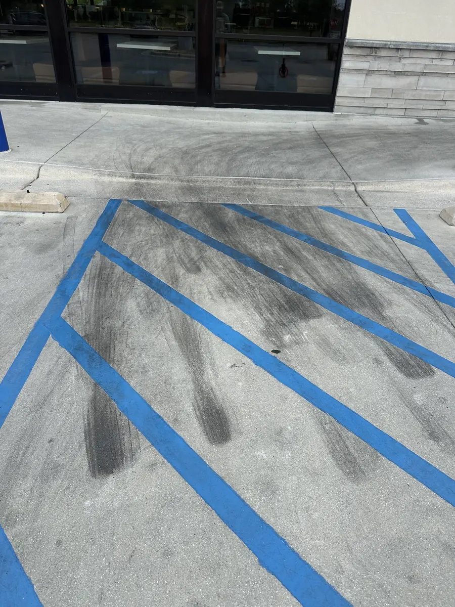Before: heavy black tire marks staining the ADA access aisle at a Jacksonville, NC restaurant