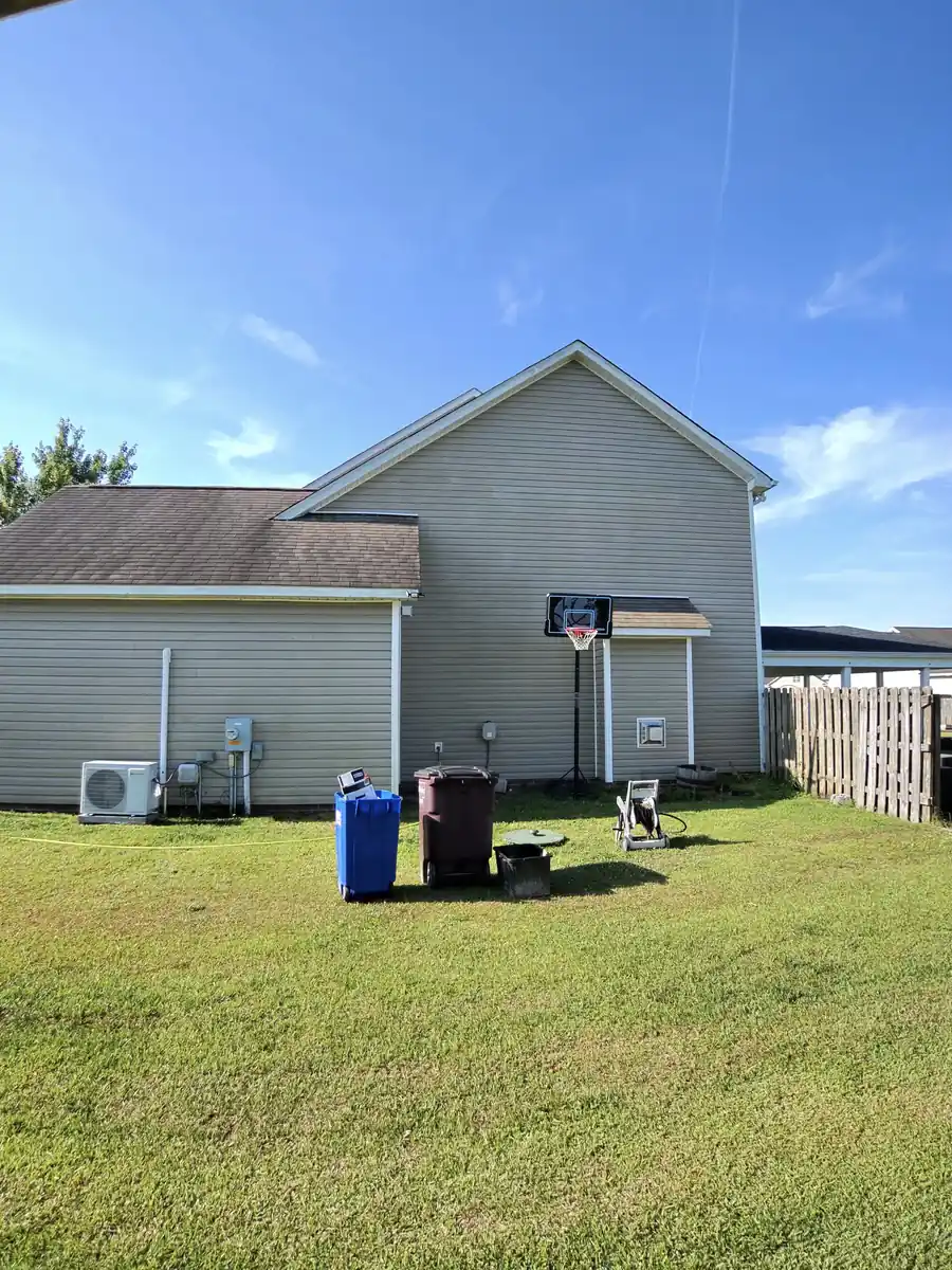 After: side of gray vinyl home cleaned next to basketball hoop by Fresh Start Surface Solutions