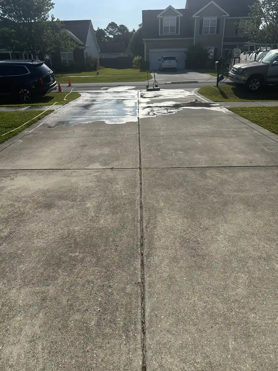 Before: two-story home driveway with staining and organic buildup before pressure washing