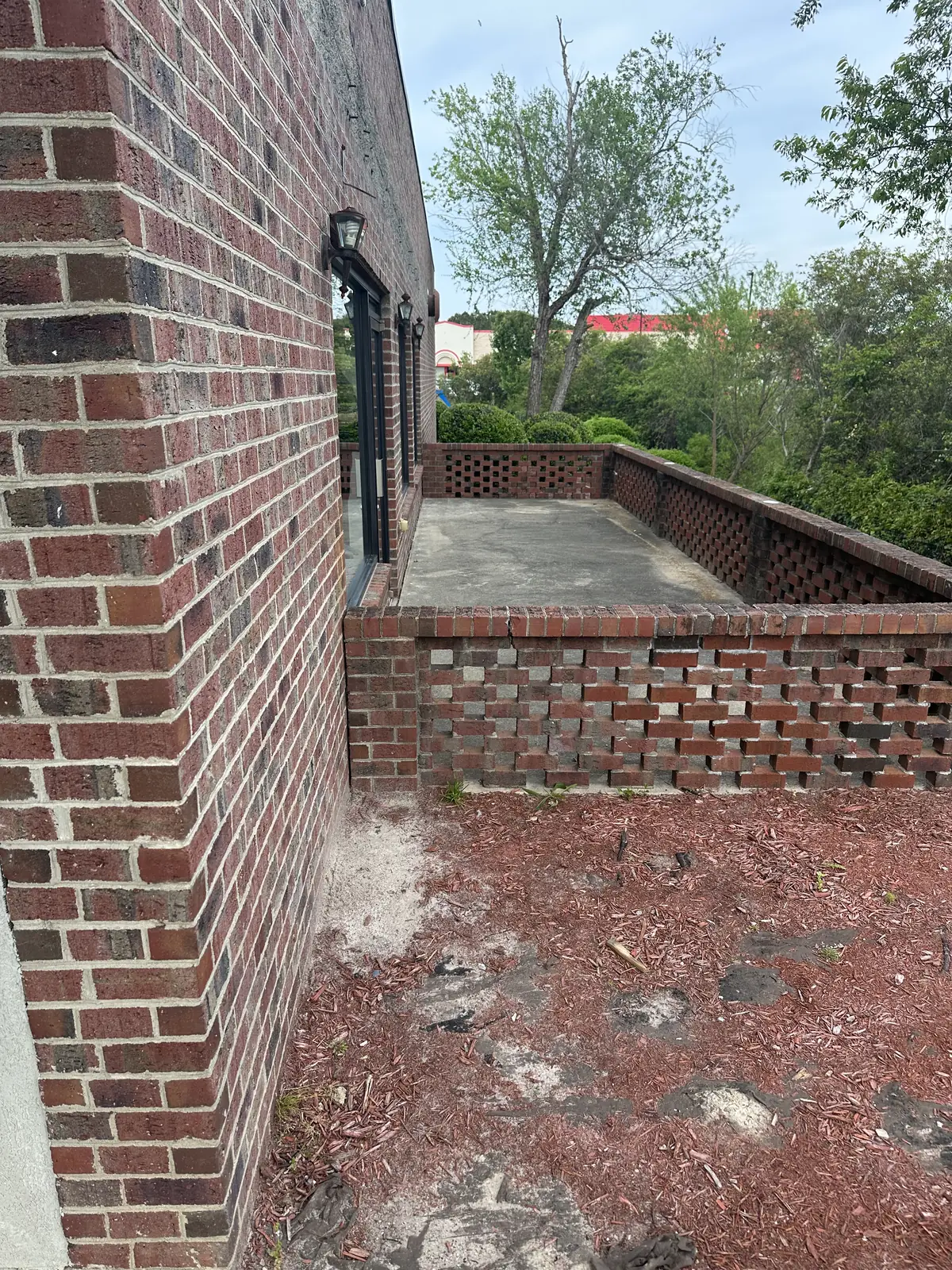 Before: commercial brick building exterior with dirt, algae, and weathering