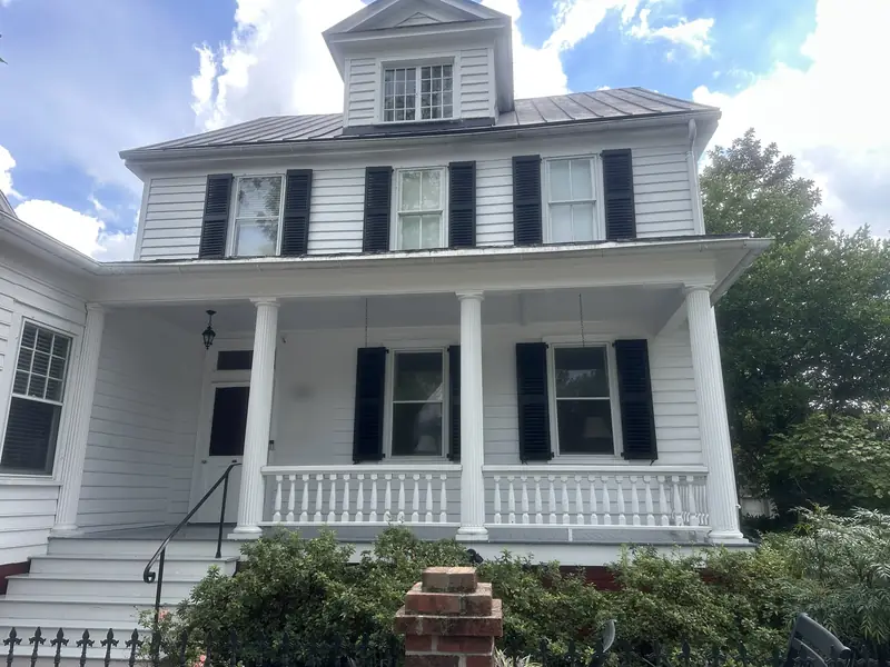 Restored 1800s historic home in New Bern NC after a gentle soft wash of the painted wood siding, columns, and metal roof